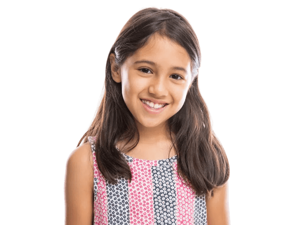 A smiling girl with long hair, wearing a colorful patterned dress, exuding happiness and warmth.